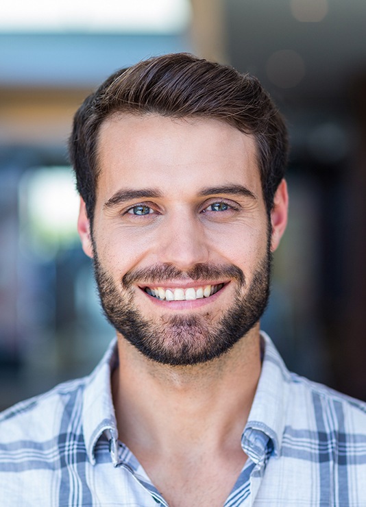 A portrait of a happy, smiling man against a blurred background